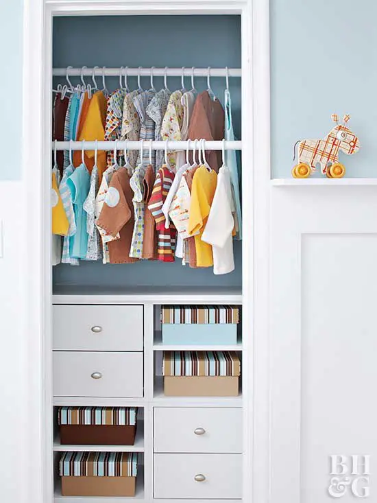 Small kids’ closet with hanging, drawers and cubbies for books by Famille Closets