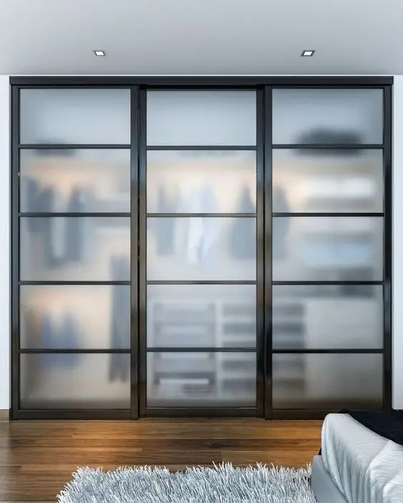 Frosted glass sliding-door wardrobe with black frames by Famille Closets