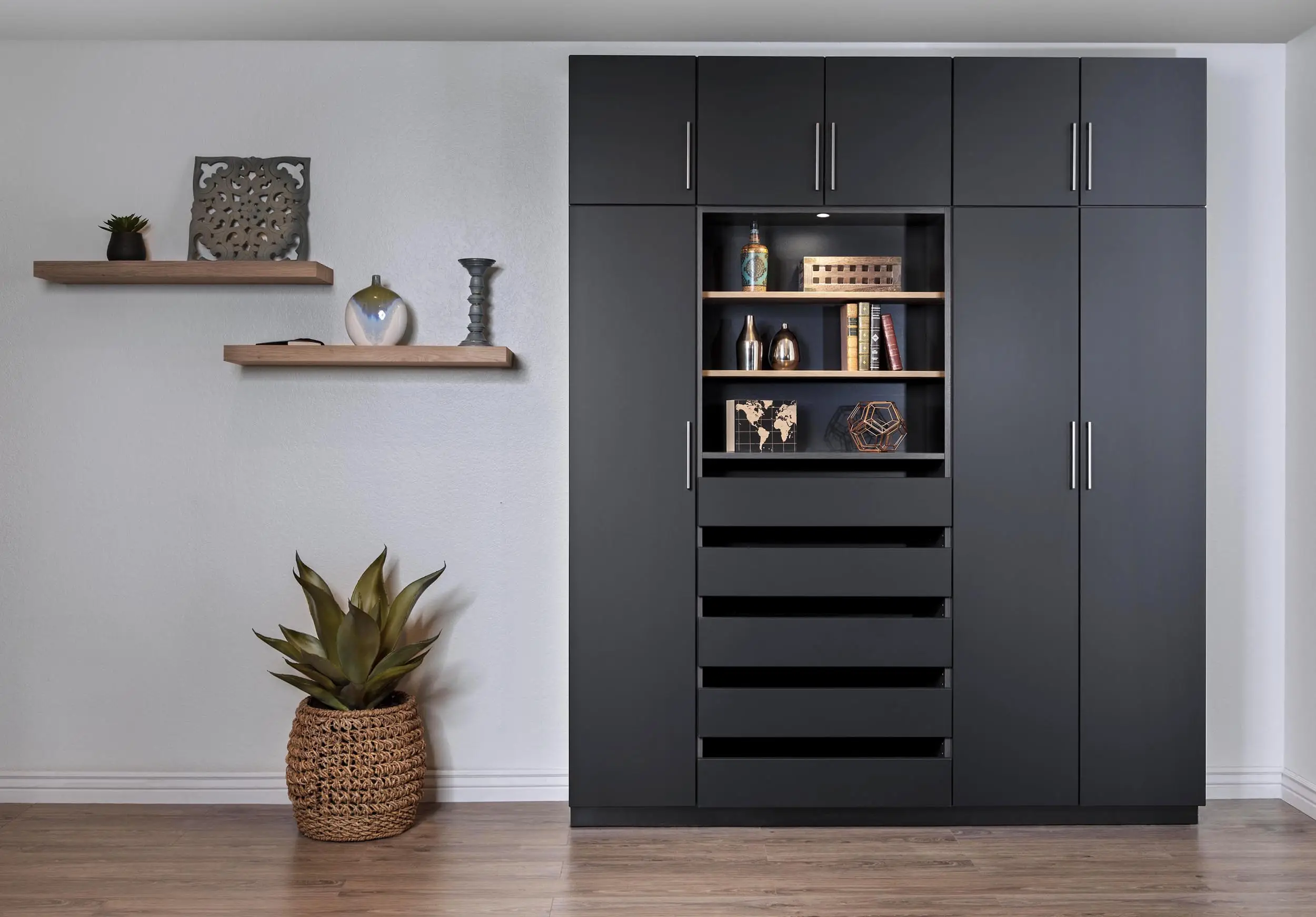 Black wardrobe wall with open display shelving and drawers by Famille Closets