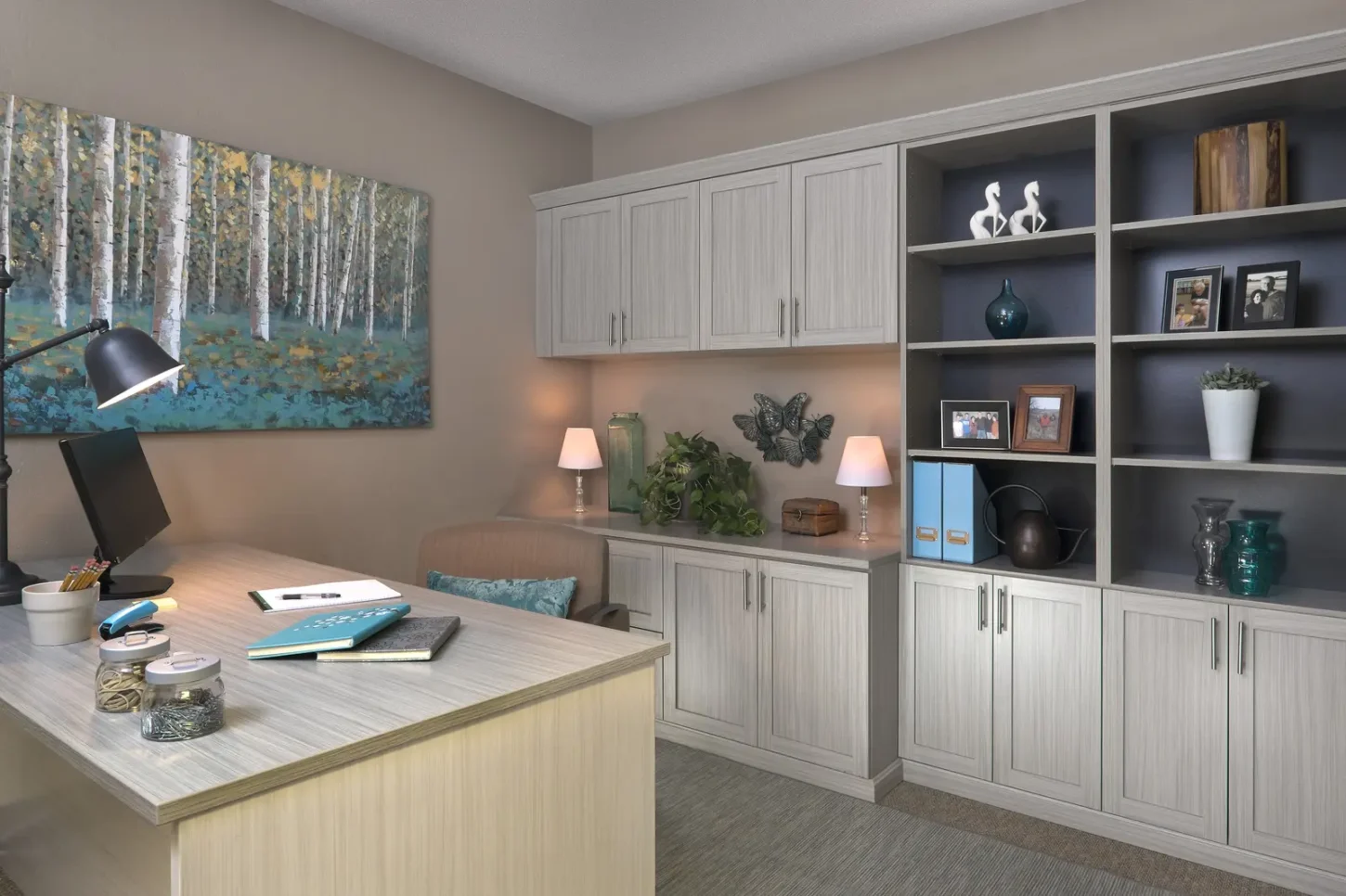 Custom home office with built-in desk, white cabinets and display shelving