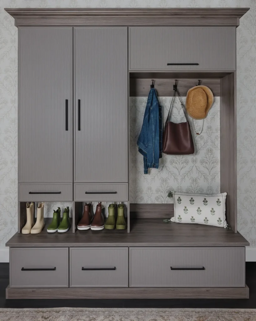 Custom mudroom storage with grey cabinets, bench seat, shoe cubbies and coat hooks