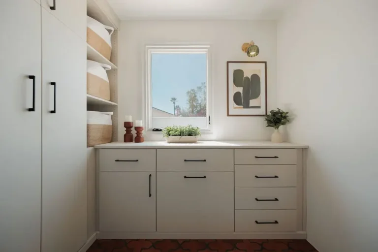 Vintage finish laundry room cabinets with drawers and a countertop under a window