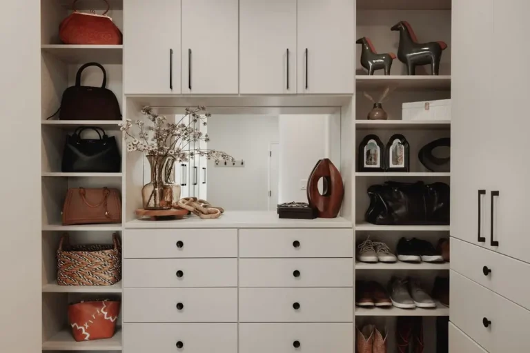 Vintage finish walk-in closet with a drawer bank, mirror, upper cabinets and open shoe and bag shelving