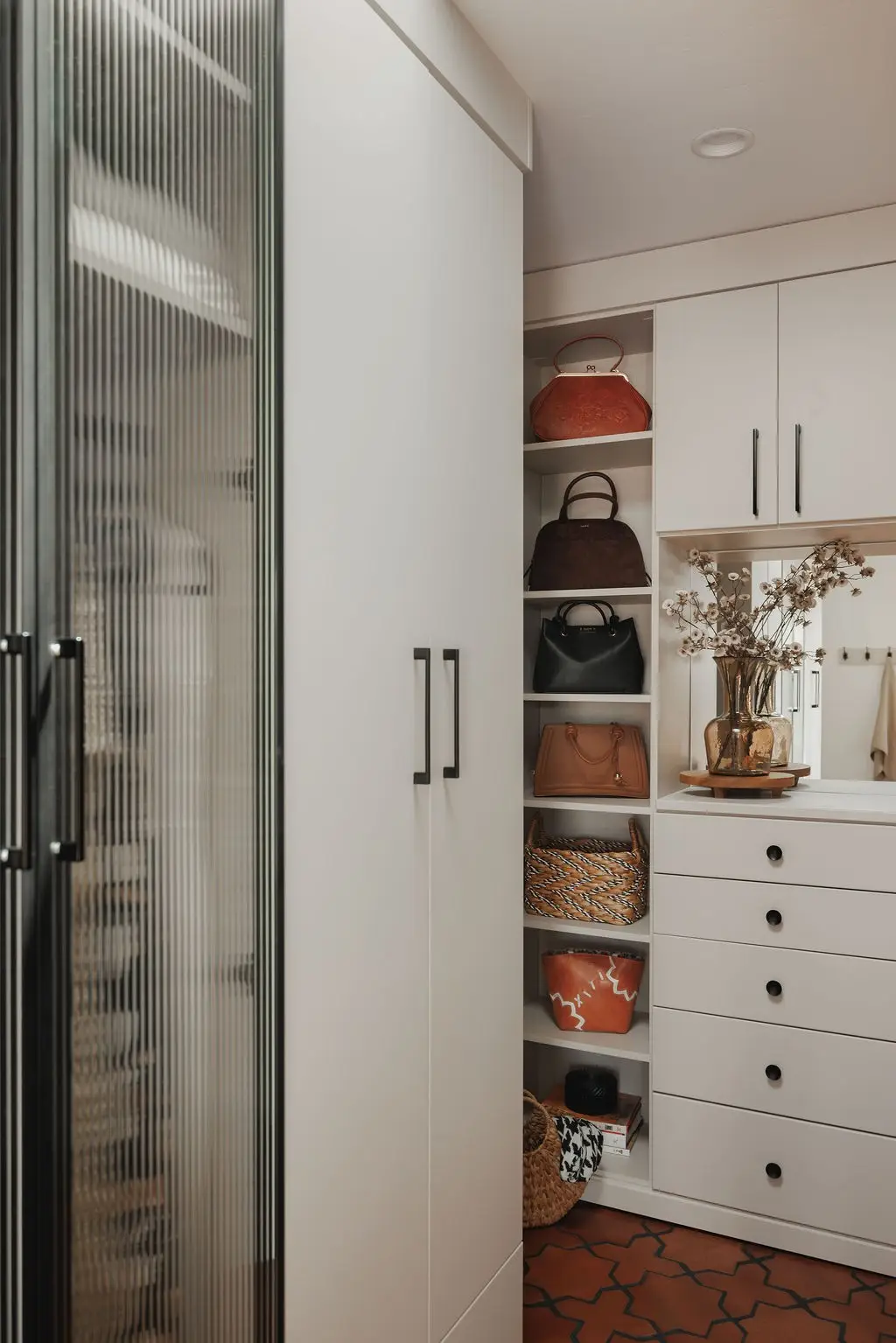 Vintage finish walk-in closet with fluted glass wardrobe doors and open shelving