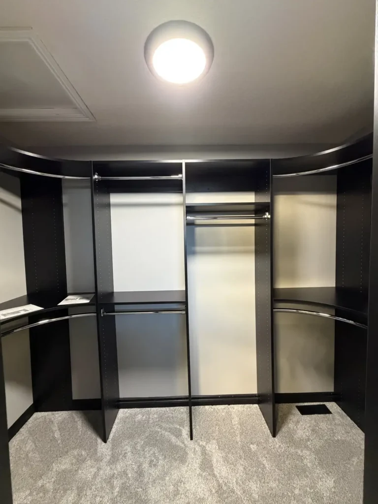 Black walk-in closet with curved corner rods in the Edmonton area, after Famille Closets installation