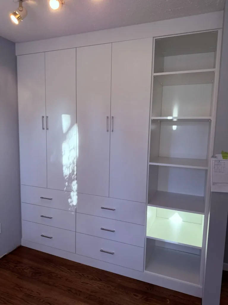 White wardrobe wall with lit display cabinet in the Edmonton area, after Famille Closets installation