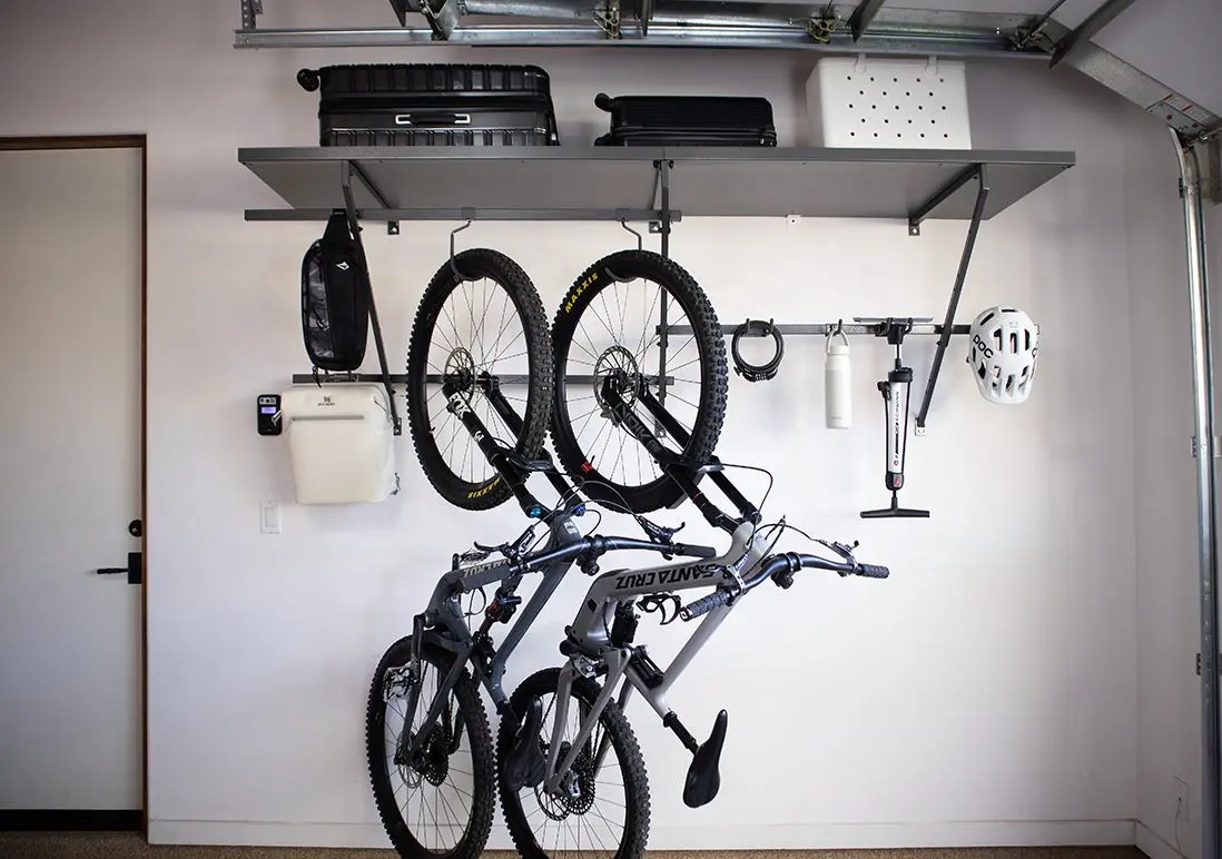 Ceiling storage rack with wall-mounted bike hooks by Famille Closets