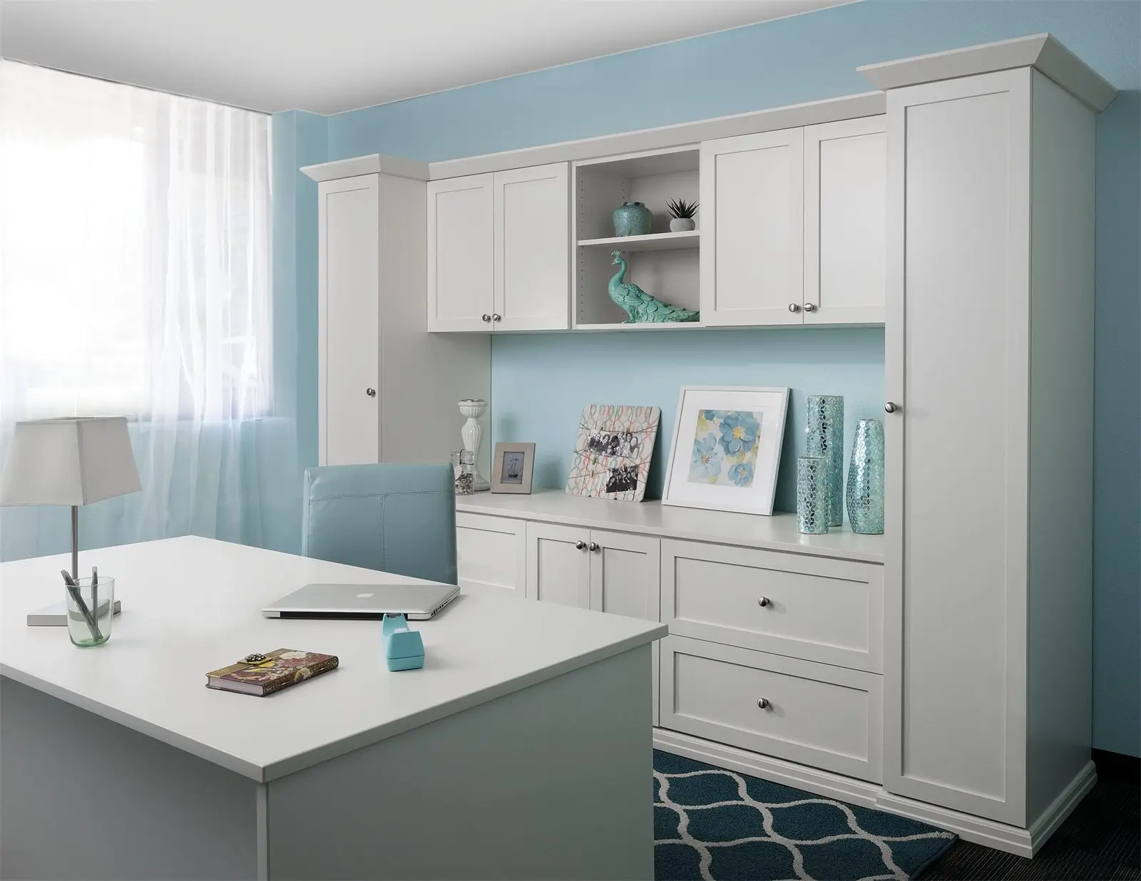 Antique white shaker home office with a desk, wall cabinets and a tall storage cabinet by Famille Closets