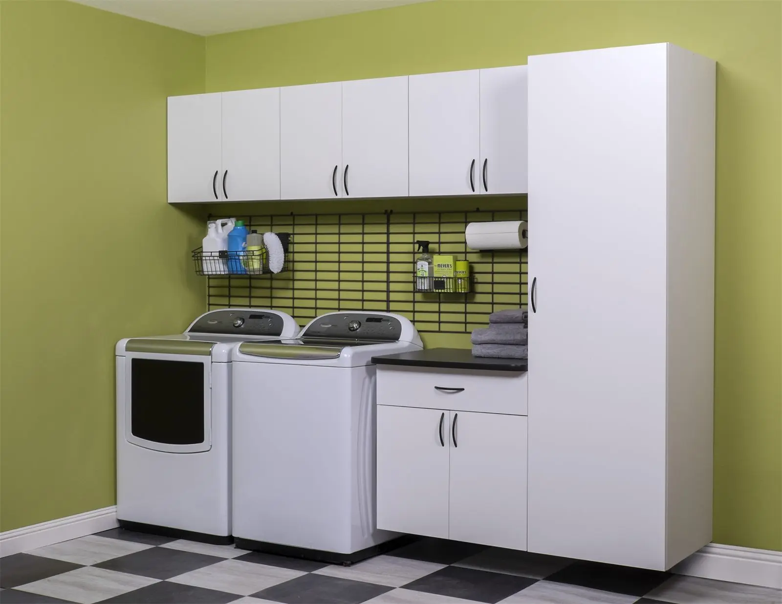 White laundry cabinets and a tall storage cabinet with a wall rack above the washer and dryer by Famille Closets