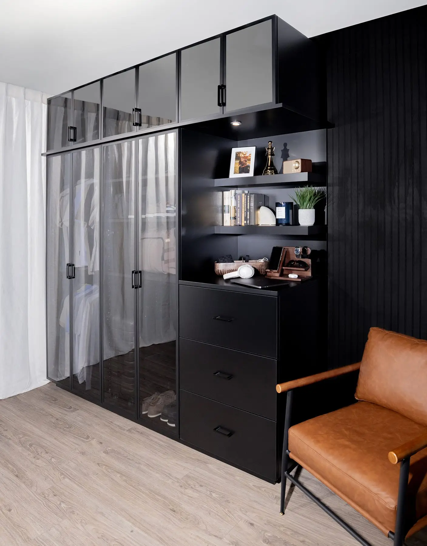 Black flat-panel walk-in closet with drawers and display shelving by Famille Closets
