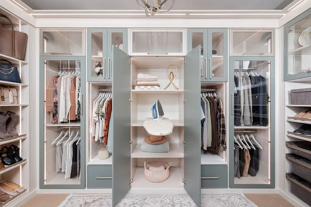Fold-out ironing board built into a closet by Famille Closets