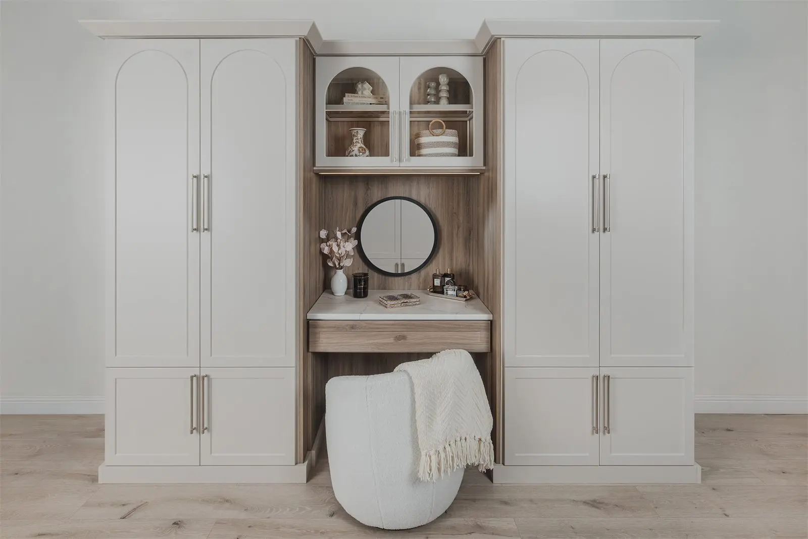 Drift and Vintage wardrobes with a built-in vanity and arched glass doors by Famille Closets