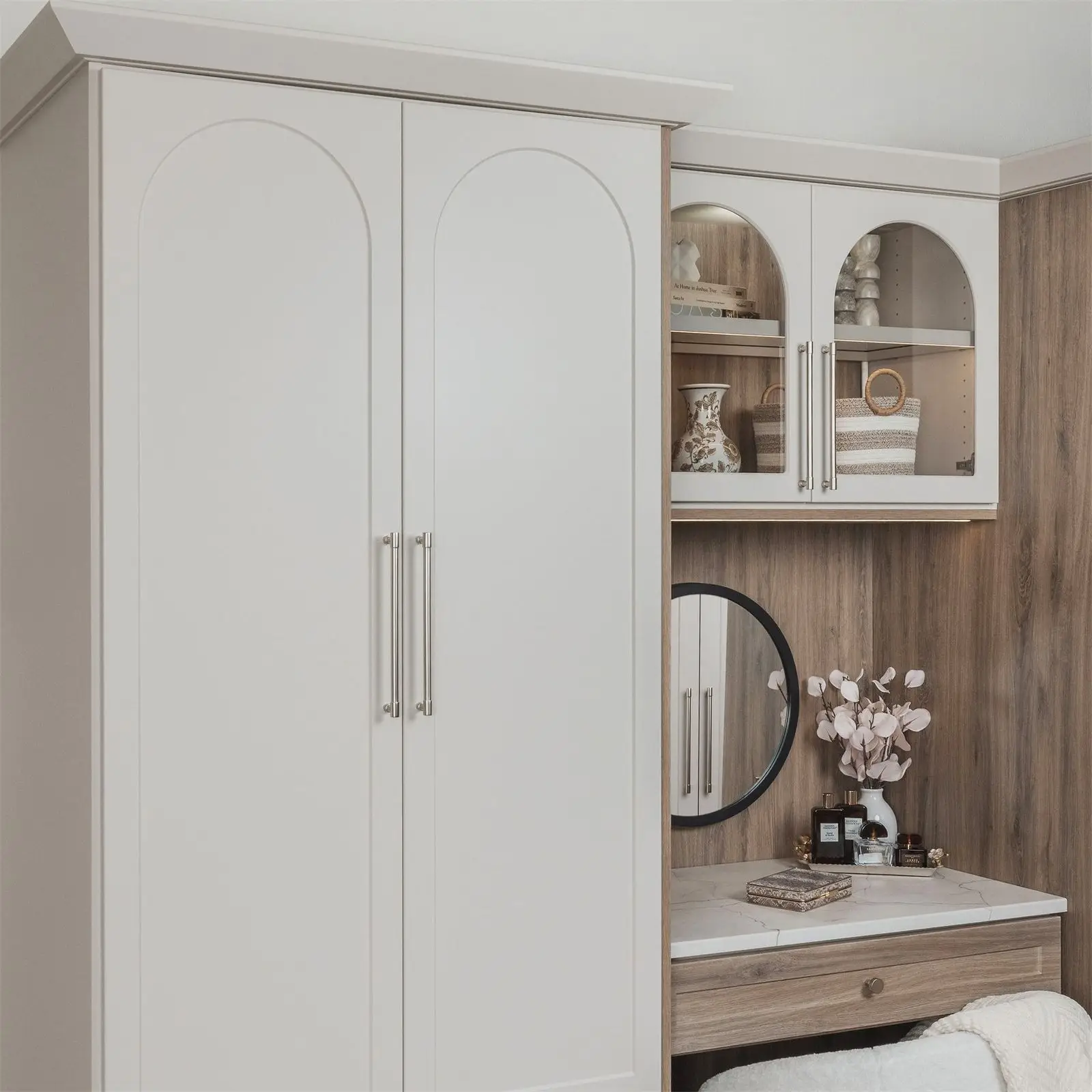 Off-white wardrobe pair with a vanity and arched display cabinet by Famille Closets